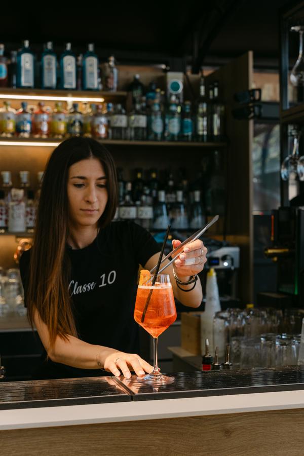 Una barista prepara uno spritz al bancone